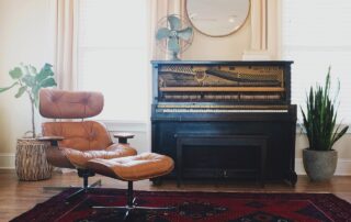Brown leather chair with an old style piano.