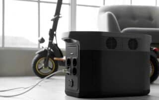 Portable power station charging electric bike on floor in living room