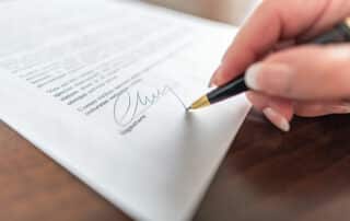 Woman hand signing a contract.