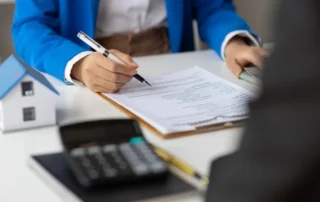 Real estate agents negotiate for businessman to legally sign home purchase agreements contract , rent, mortgage, lease. Businesswoman signs house purchase contract.