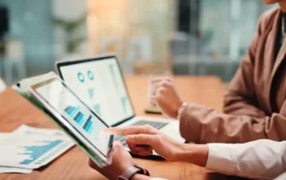 Hands, people and graphs on tablet screen for finance results, profit growth and budget review. Staff, team and digital with financial report, revenue stats and dividend comparison of risk assessment
