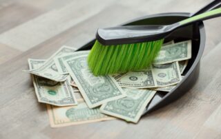 Dollars on the floor being swept into a bin.
